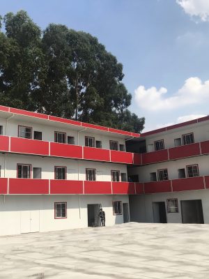 Red four-slope roof T-shaped prefabricated house