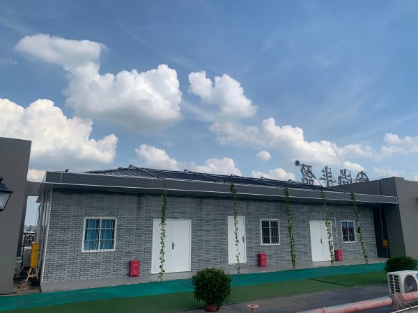 Dark gray quadrangle-style traditional T-shaped prefabricated house
