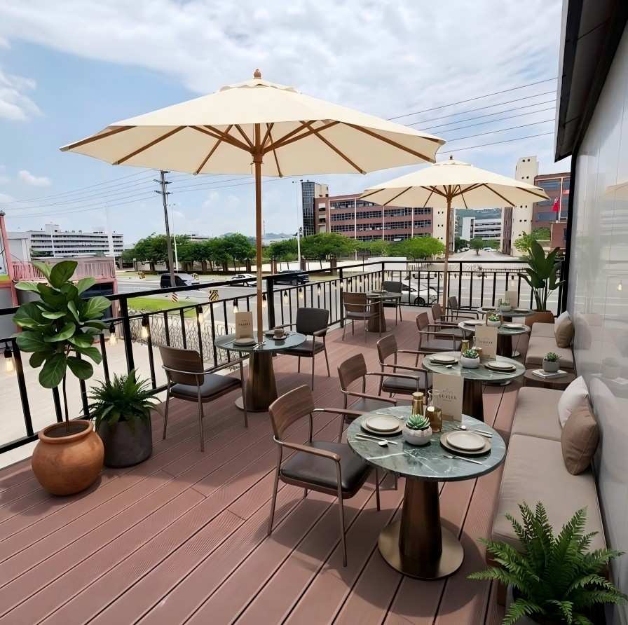 Outdoor rooftop seating area of a modern double-story container coffee shop with terrace umbrellas