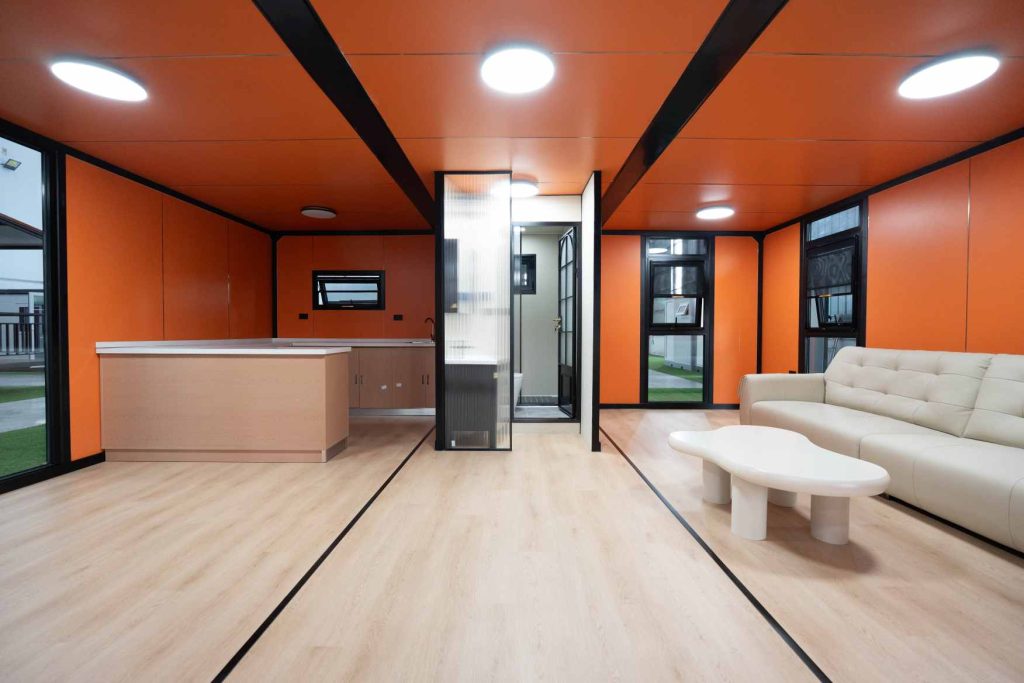 Modern interior of expandable container home featuring living room, kitchenette and bathroom layout