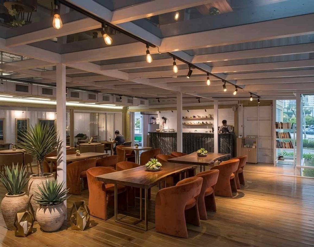 Modern panoramic glass coffee shop with steel frame construction and open seating area