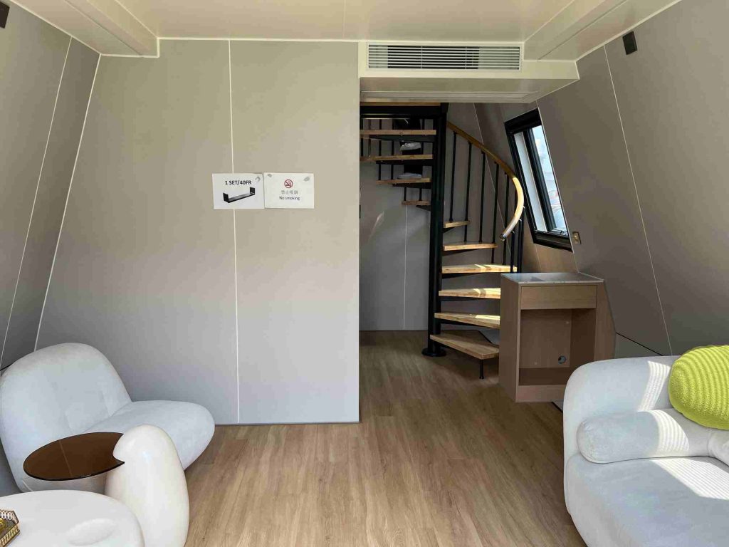 Living room and spiral staircase in a double-story triangular-module residence